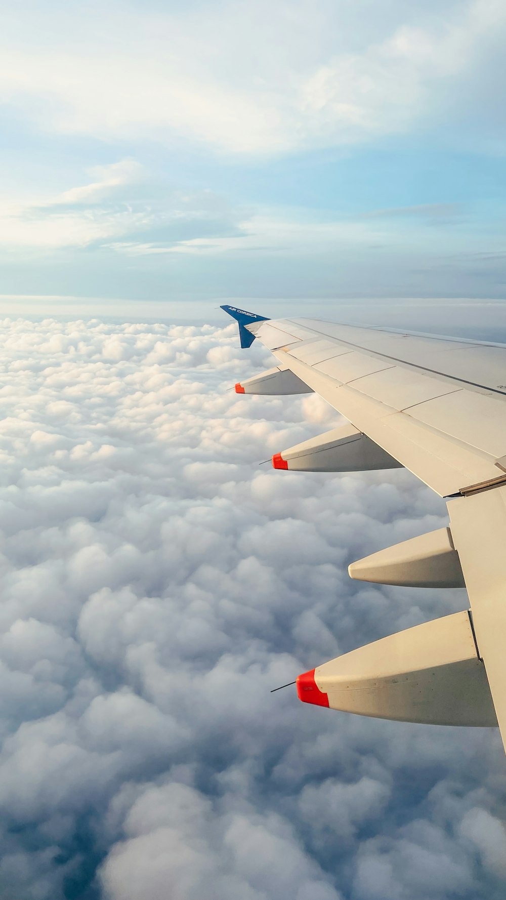 the wing of an airplane above clouds