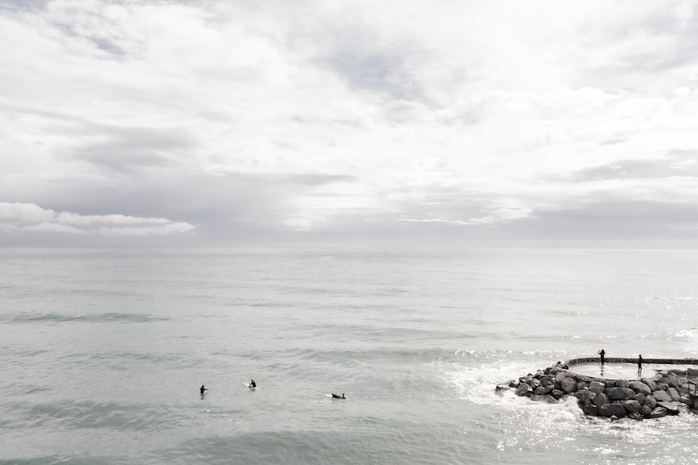 a body of water with rocks and a cloudy sky