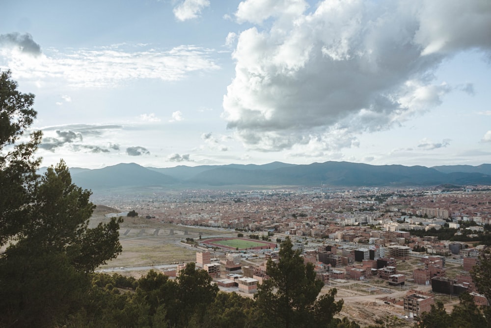 Una ciudad con árboles y montañas al fondo