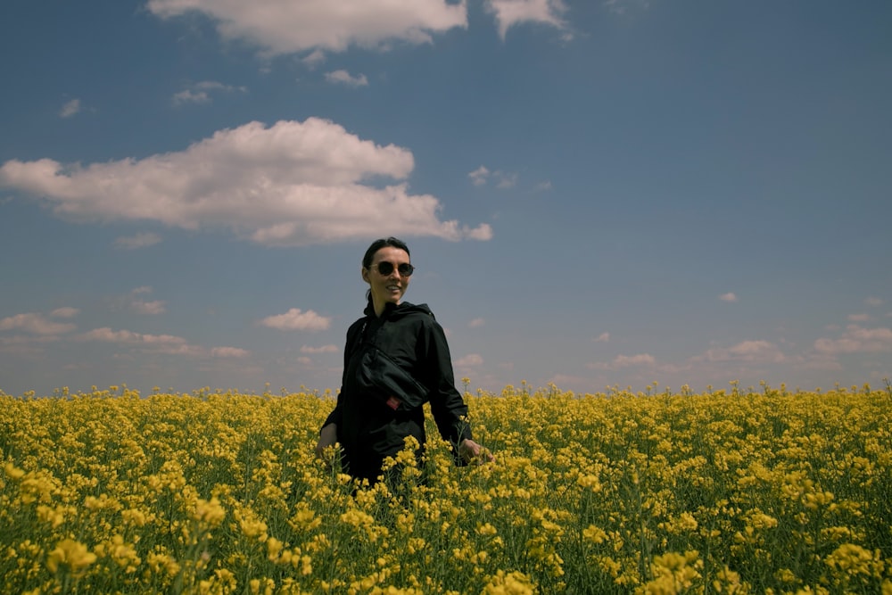 Un hombre parado en un campo de flores amarillas