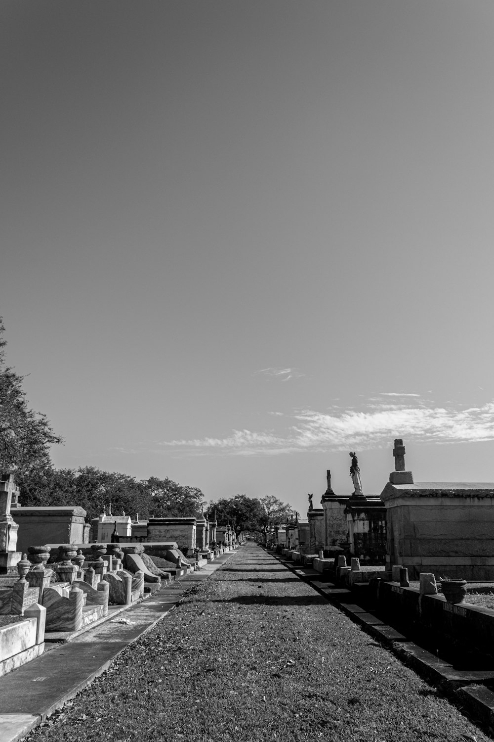 a road with a statue on the side and buildings on the side