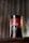A cylindrical container with the label 'DEZER HERBAL' is placed on a wooden surface. The container features a red and black color scheme with floral designs and appears to store herbal tea. The text 'Hoor Red Tea' is visible on the bottom part of the label. A blurred background with vertical lines adds depth to the image.