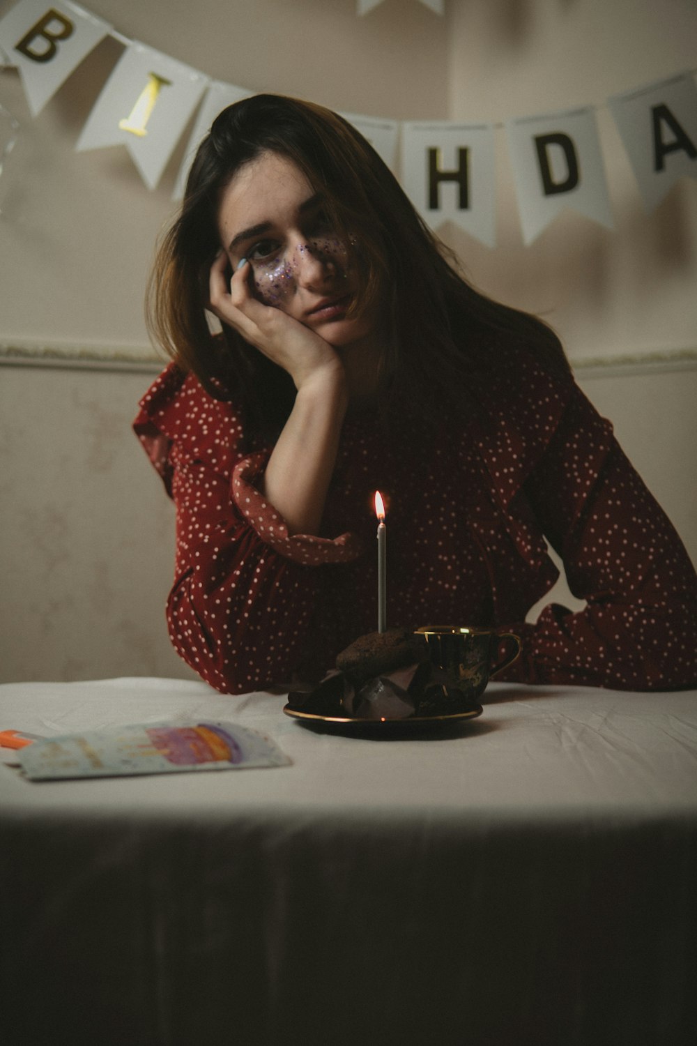 a woman sitting at a table with a candle in front of her