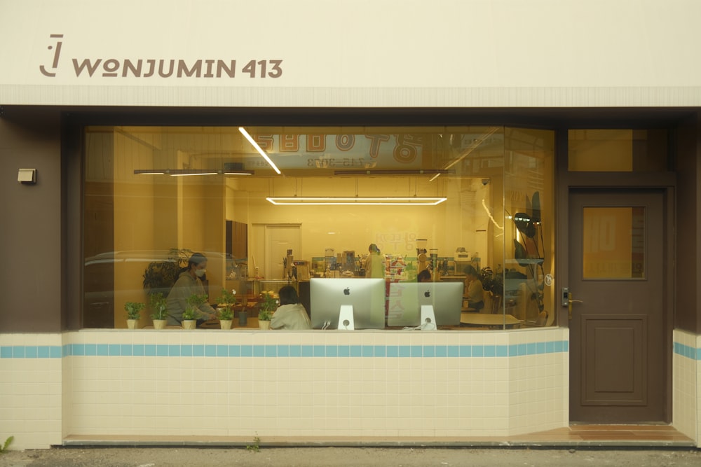 a person sitting at a desk in a window of a store