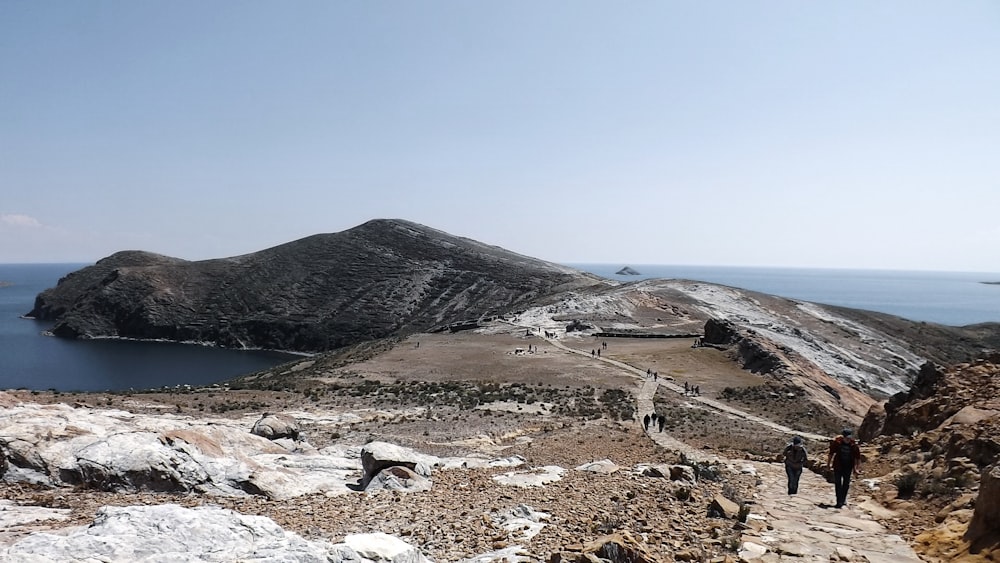 people walking on a rocky beach