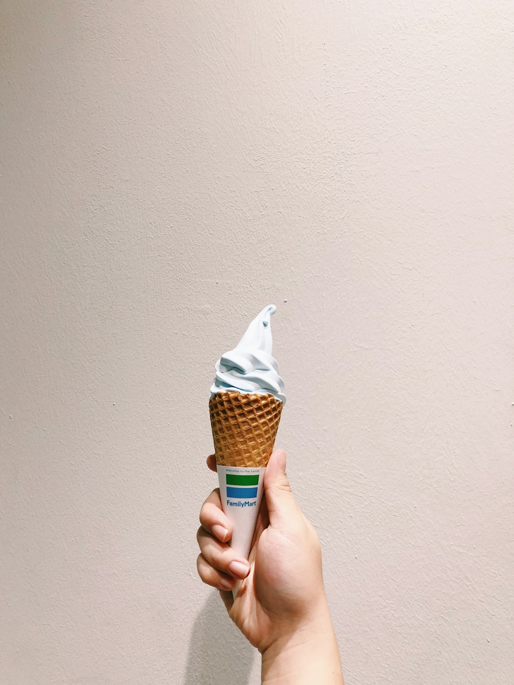 a hand holding a cone shaped ice cream cone