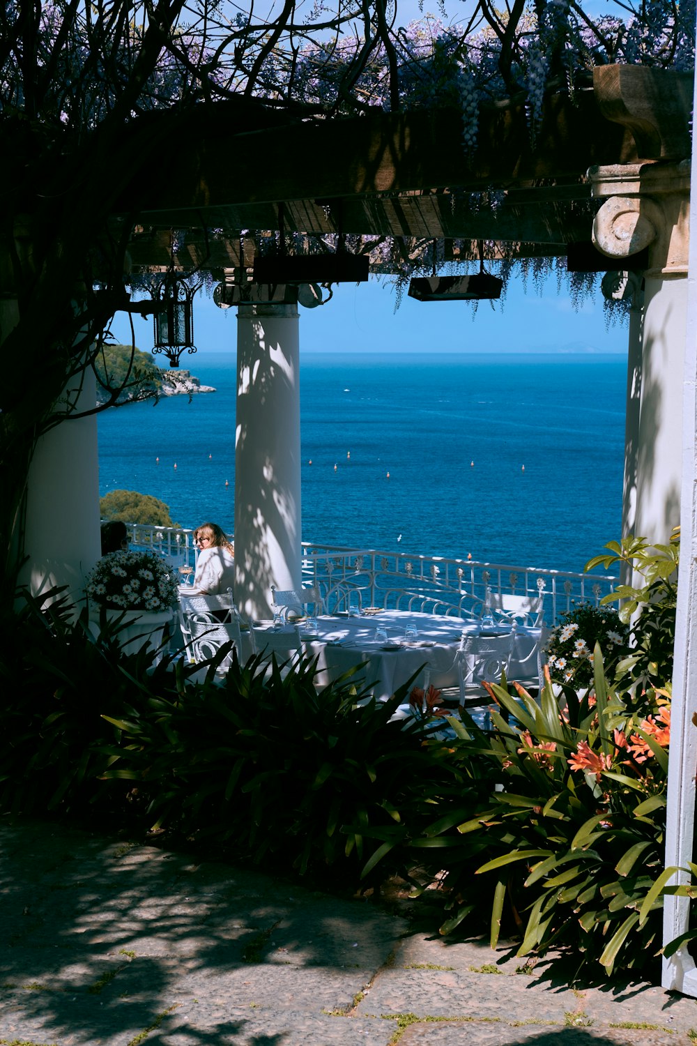 a person sitting at a table in front of a pool