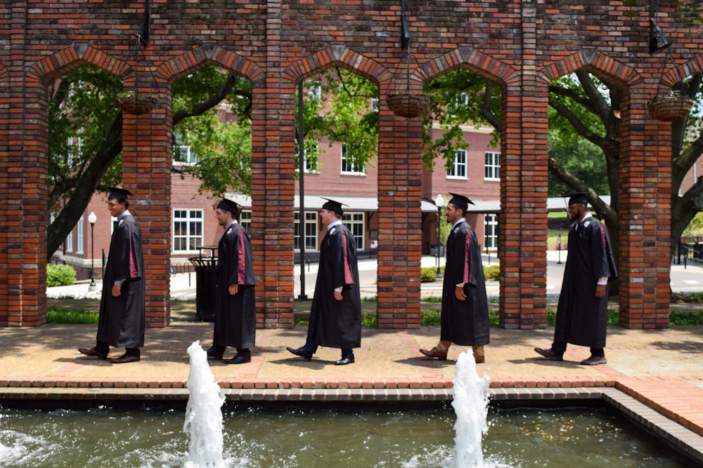 a group of men in uniform standing next to a fountain