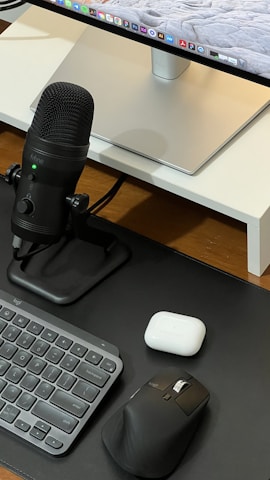 A neatly arranged set of computer peripherals including a mouse, keyboard, and headset with teal accents.