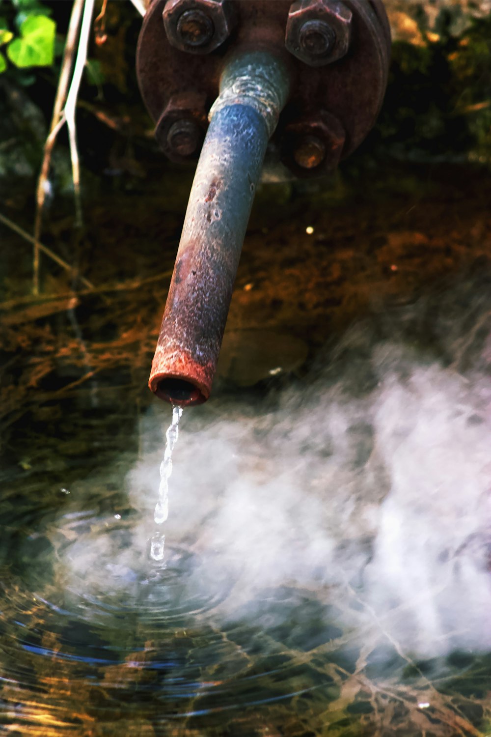 une fontaine d’eau avec un tuyau en métal