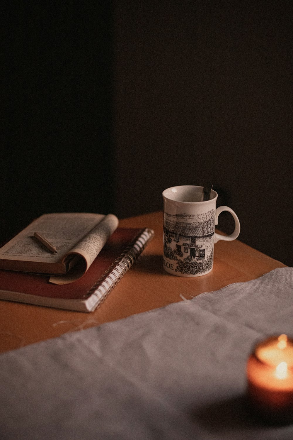 a candle and a mug on a table