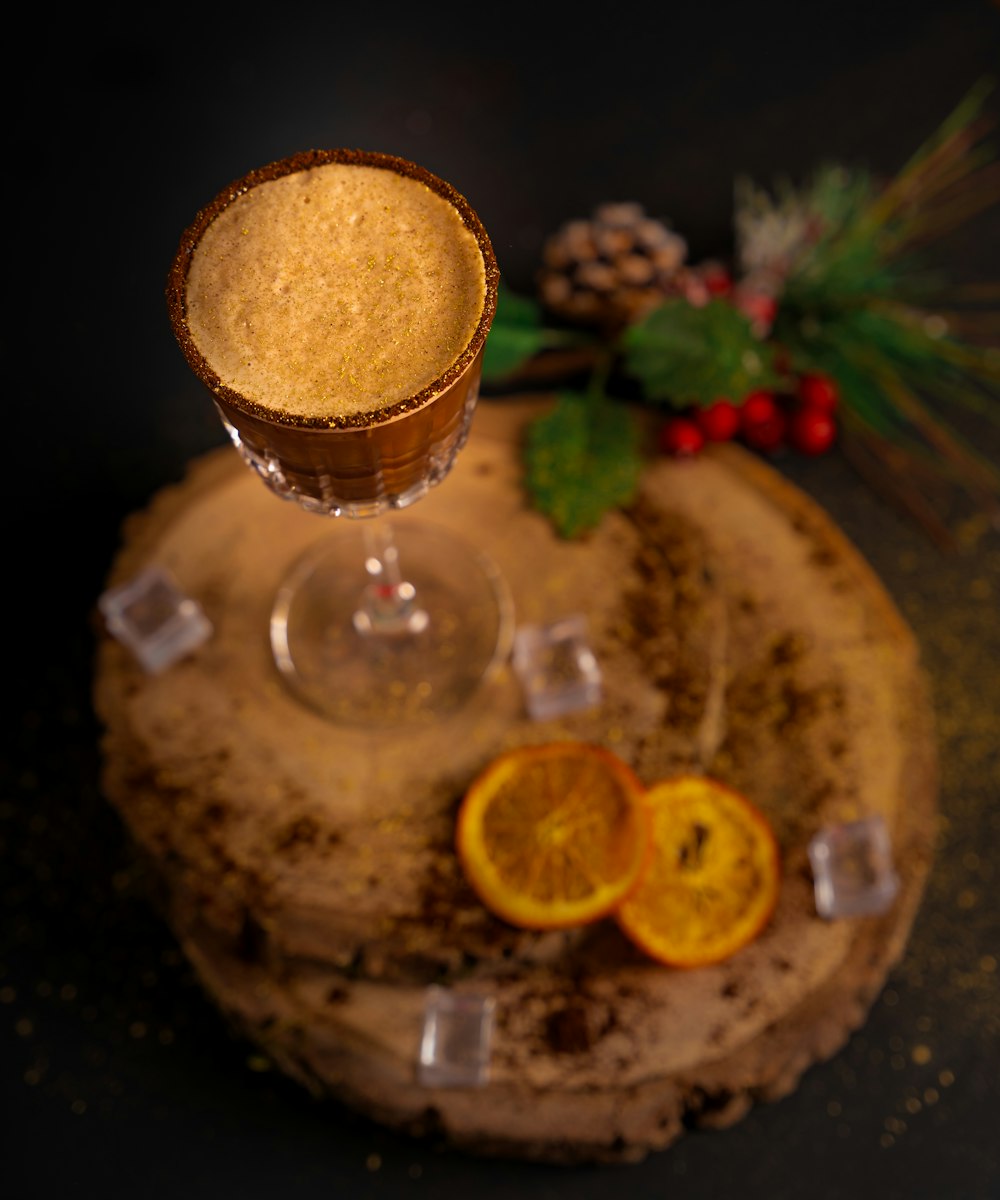 a glass of liquid with fruit and a straw