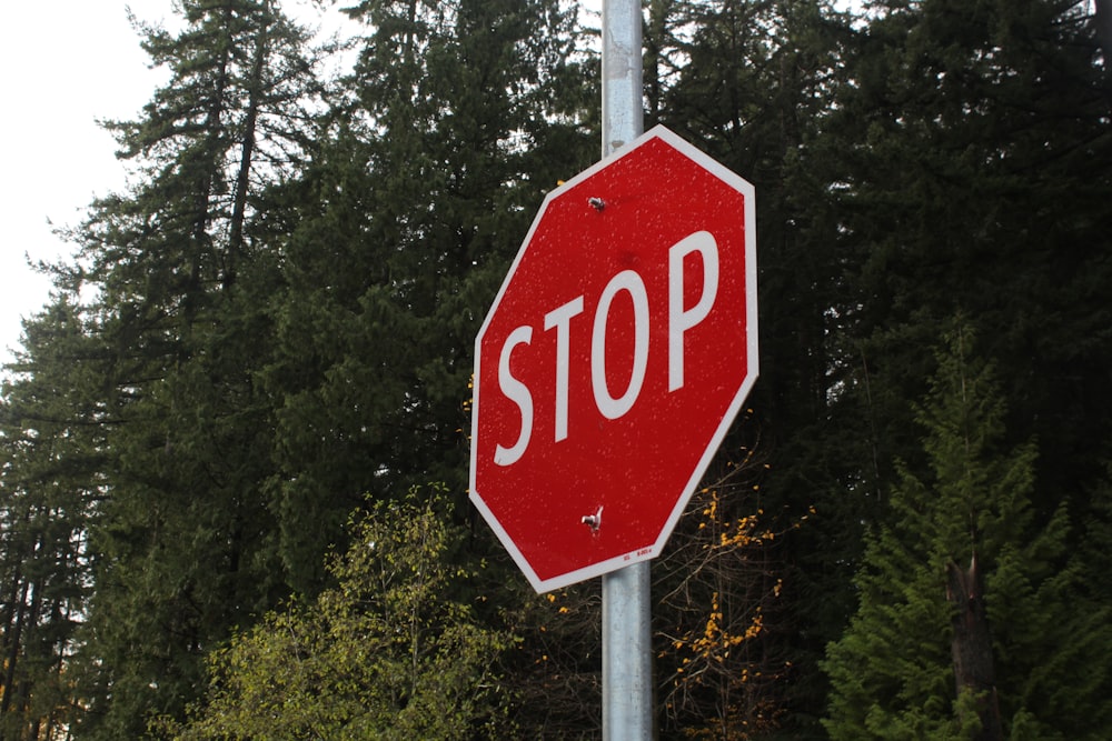 a stop sign in front of trees