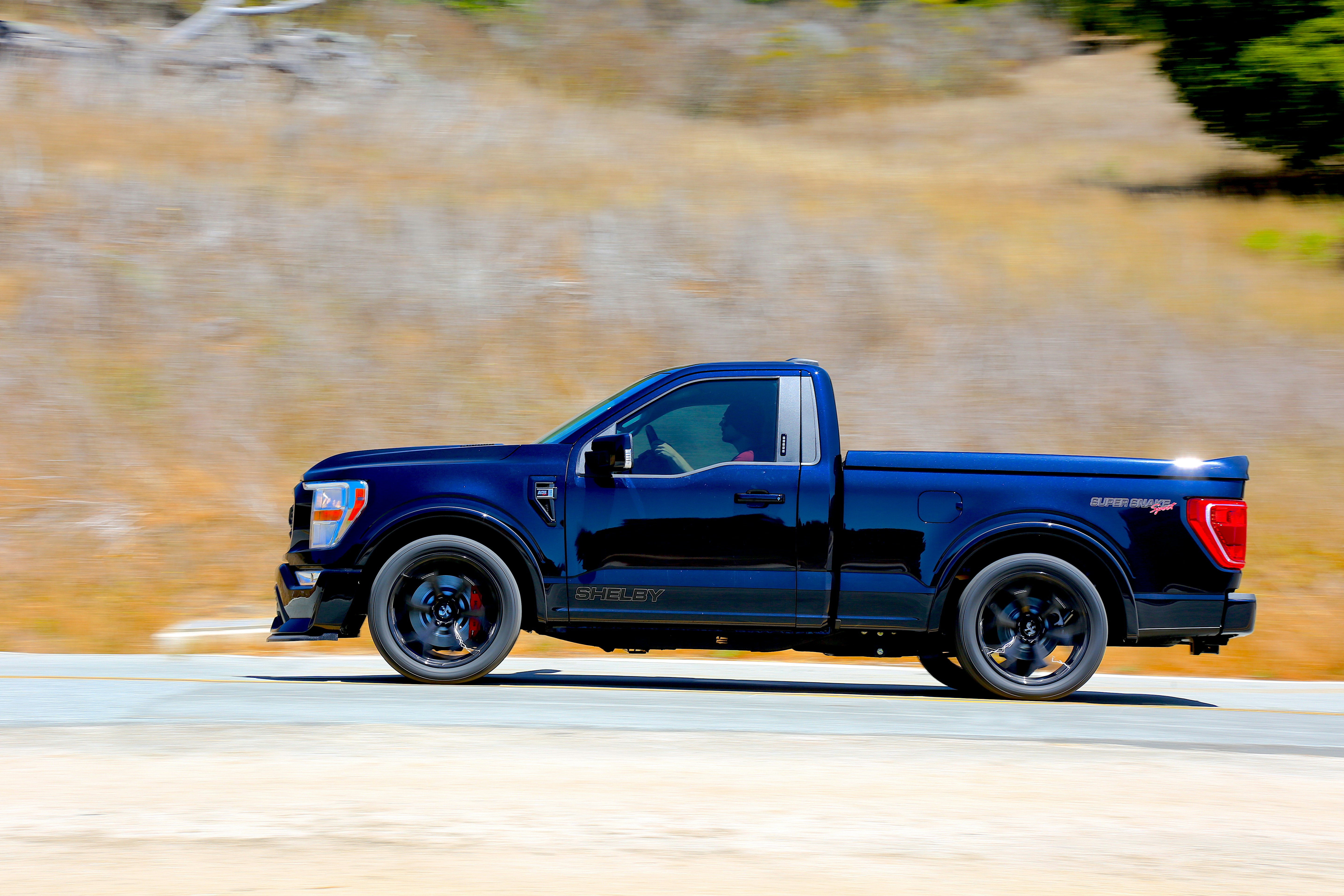 a blue pickup truck on a road