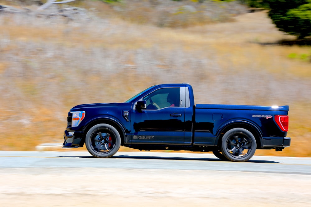 a blue pickup truck on a road