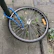 A sturdy security disc lock securing a motorcycle wheel in an urban parking lot.