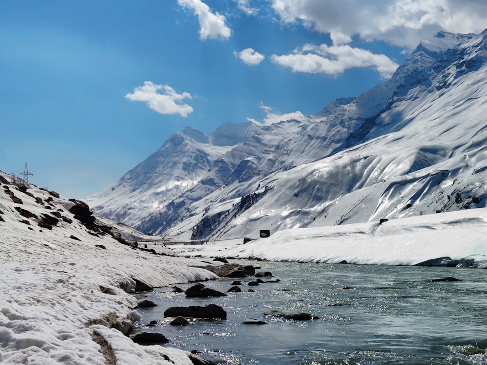 a body of water with a snowy mountain in the background