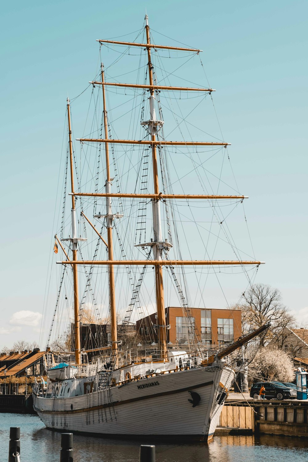 a large sailboat docked with HMS Warrior 1860 in the background