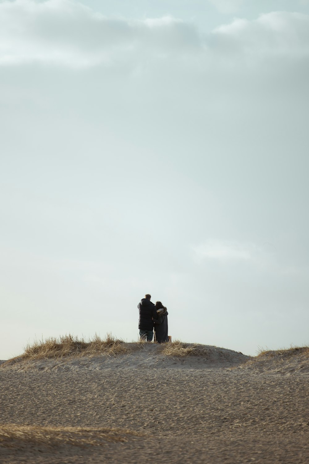 a couple people standing on a hill