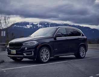 A sturdy black SUV parked in front of a mountain backdrop.