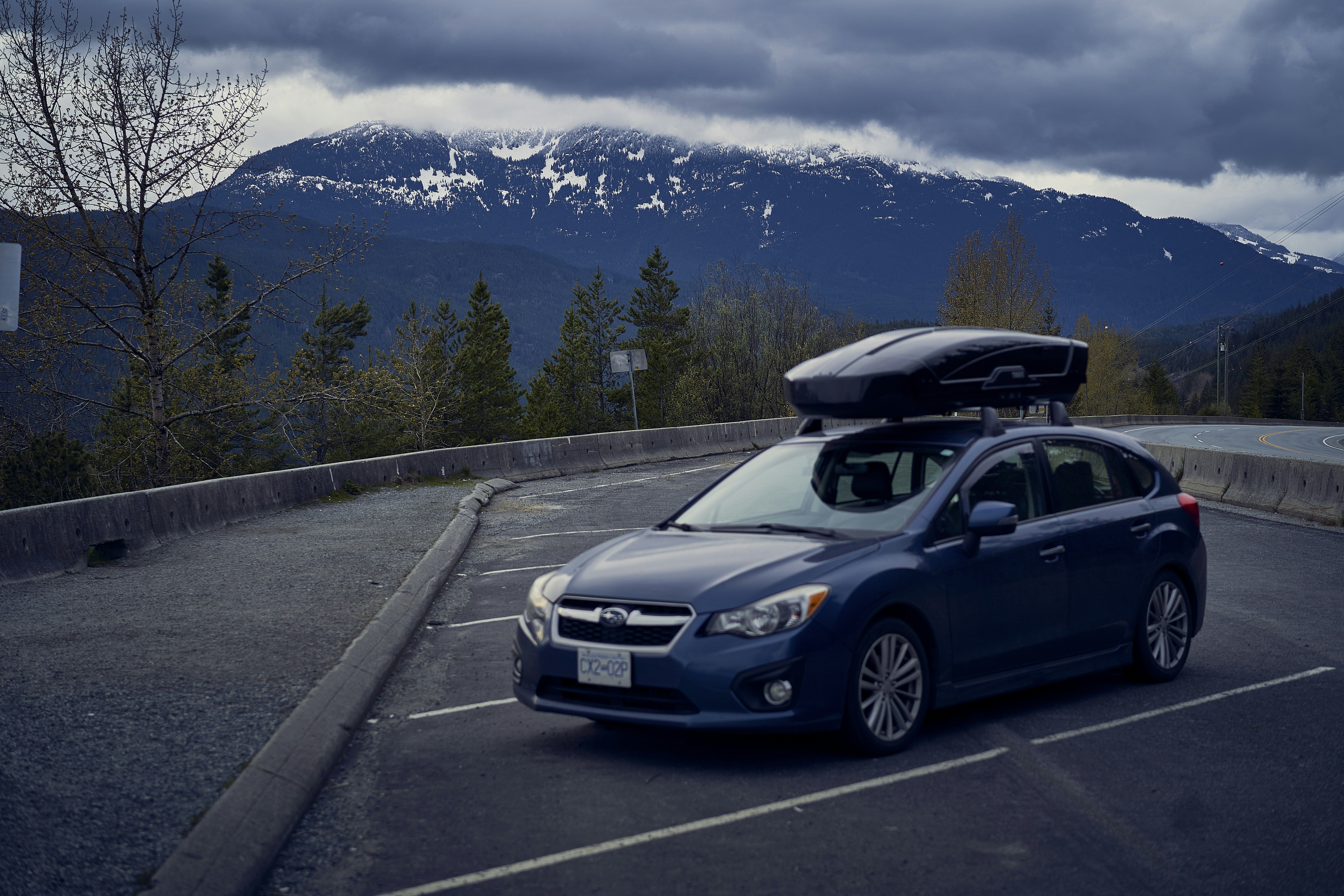 a car with a spoiler on top of it on a road with mountains in the background