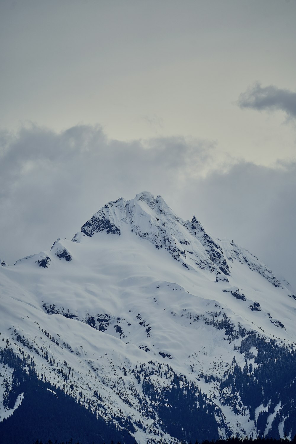 a snowy mountain with clouds