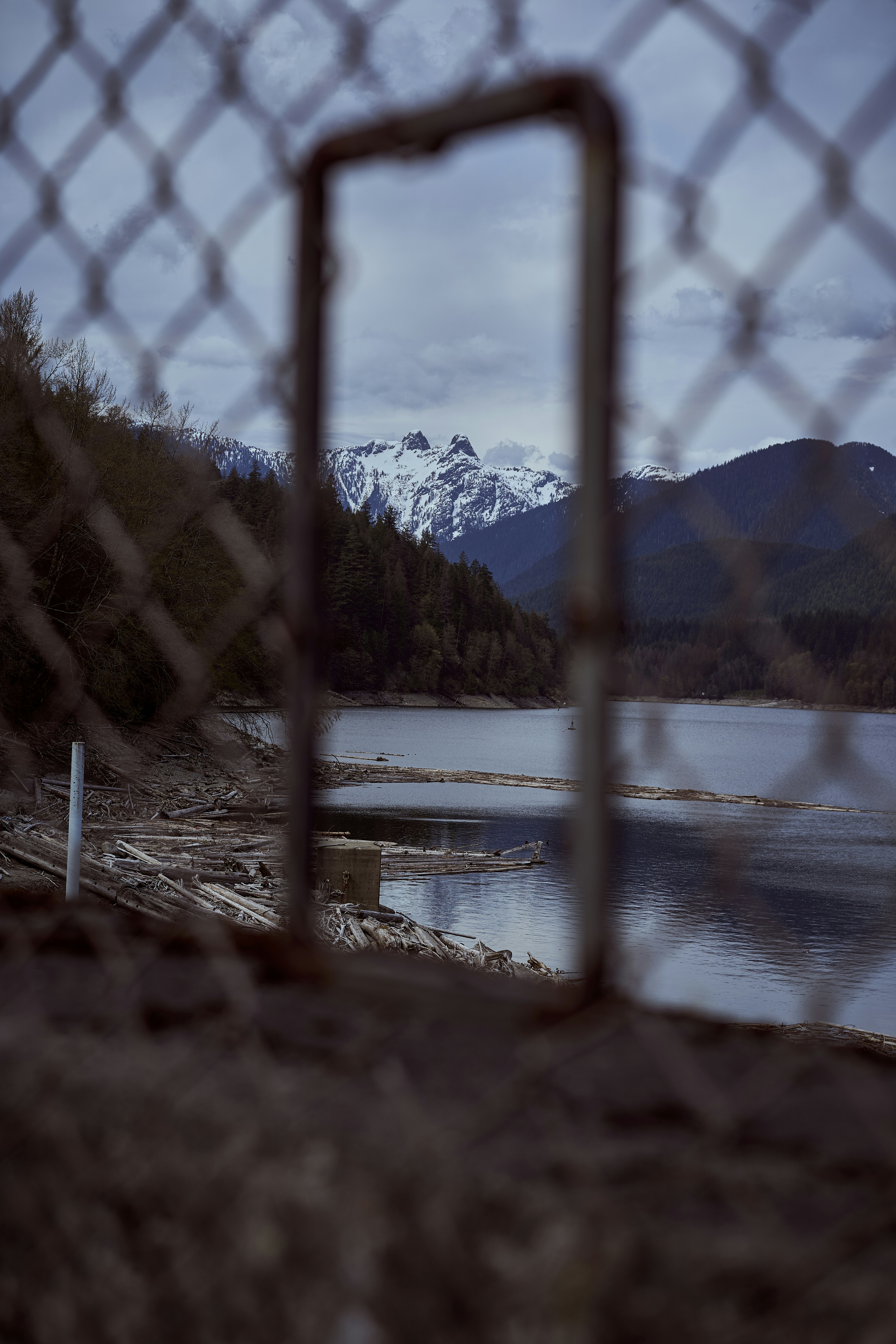 a metal frame in front of a lake and mountains