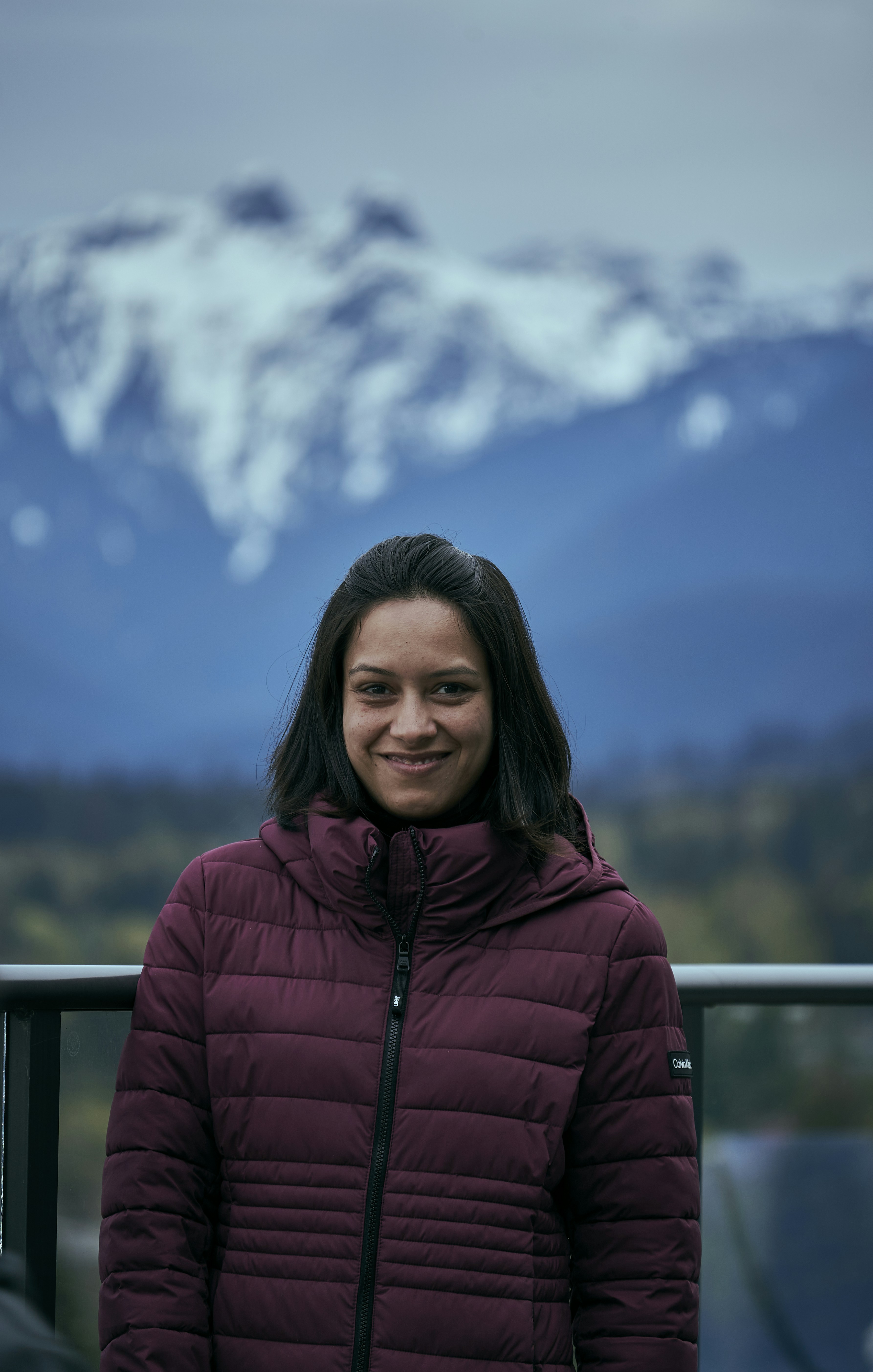 a woman smiling with a mountain in the background