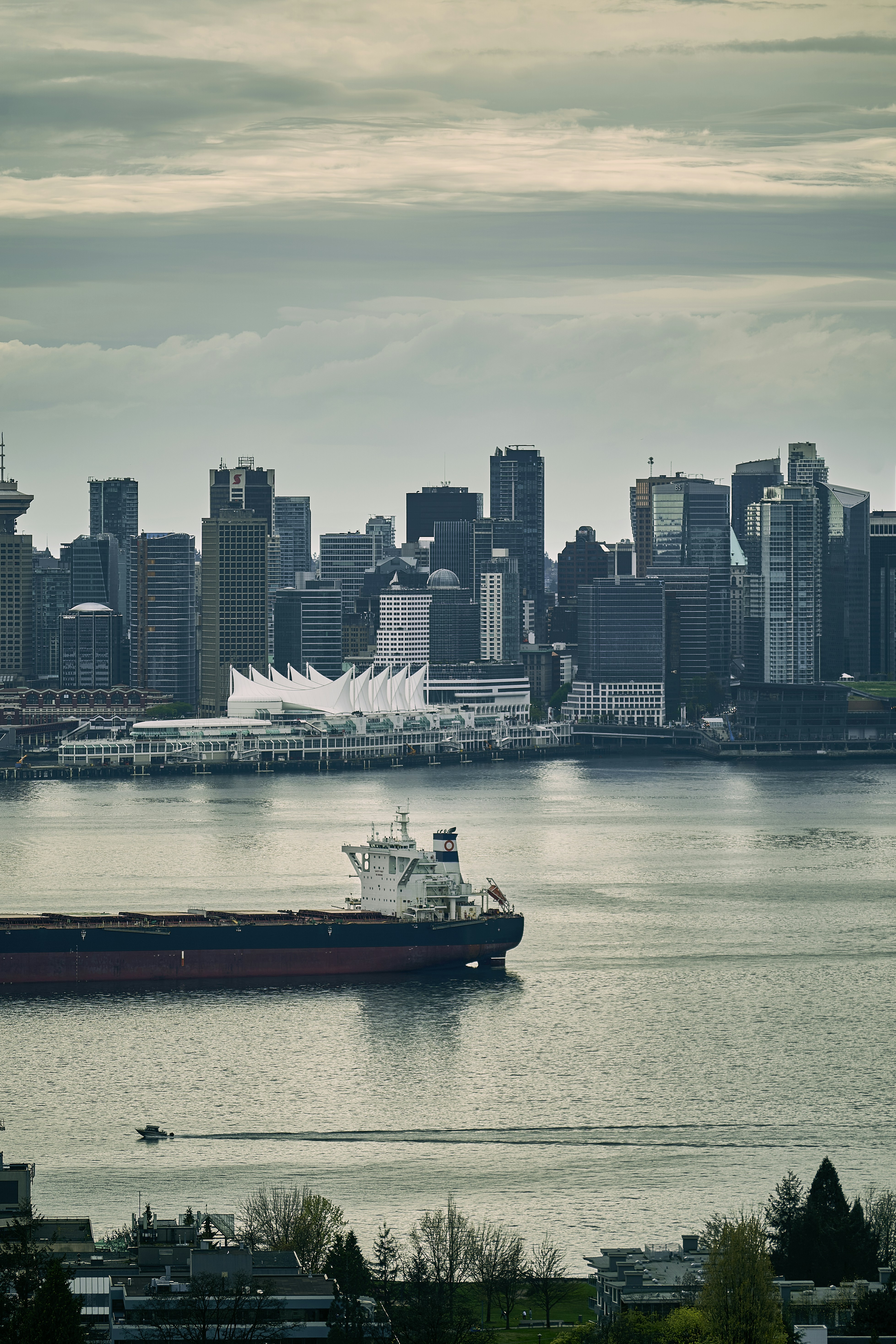 a large ship in the water with a city in the background