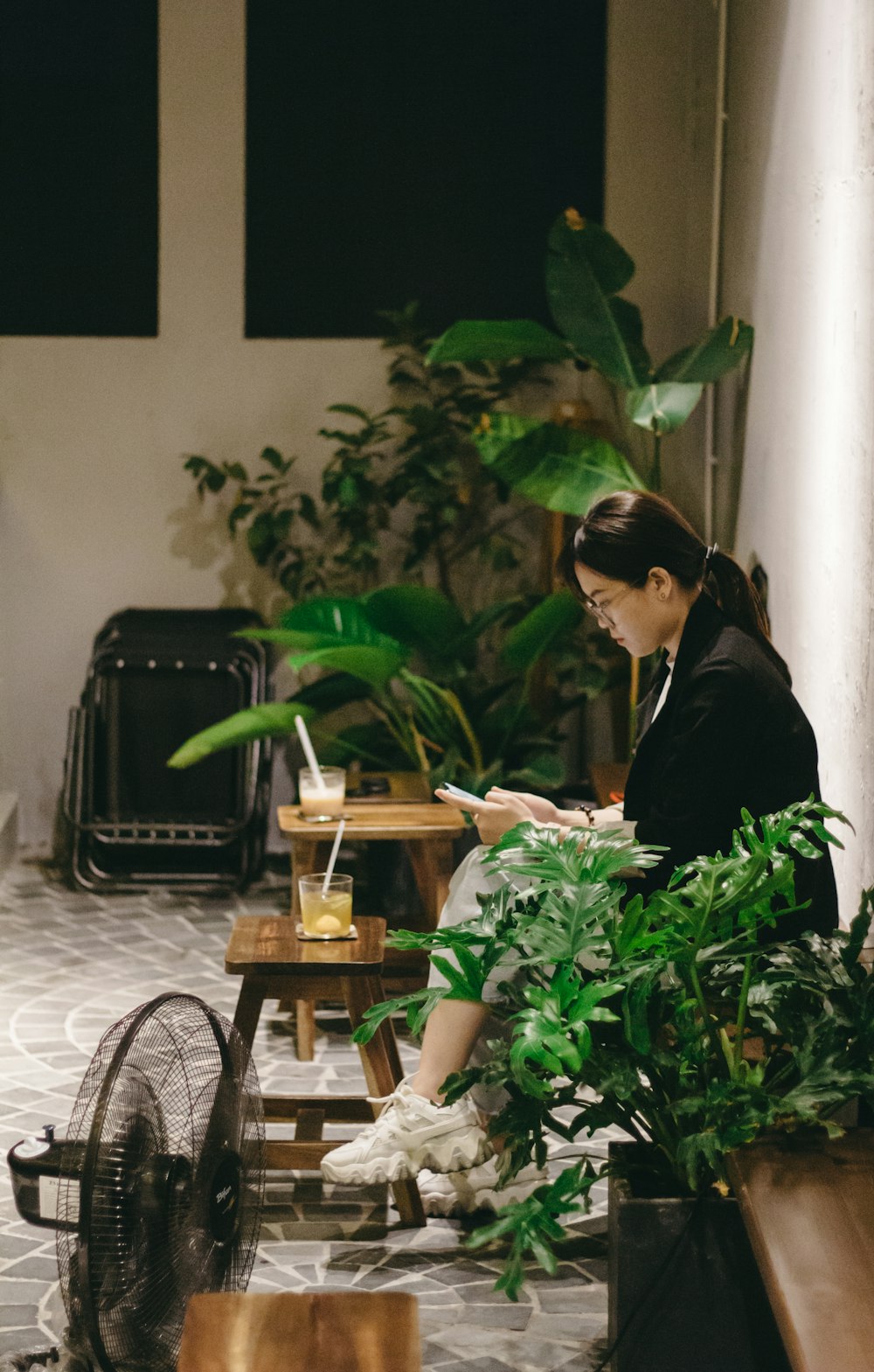 a person sitting at a table with a plant in front of the