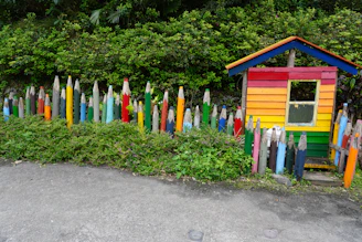 A colorful Minecraft house built with bright blocks and surrounded by flowers.