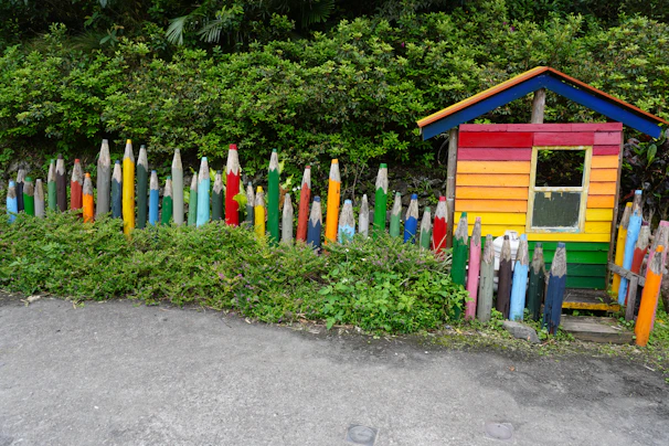 A colorful Minecraft house built with bright blocks and surrounded by flowers.