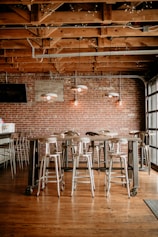 a brick wall with stools and a table in front of it