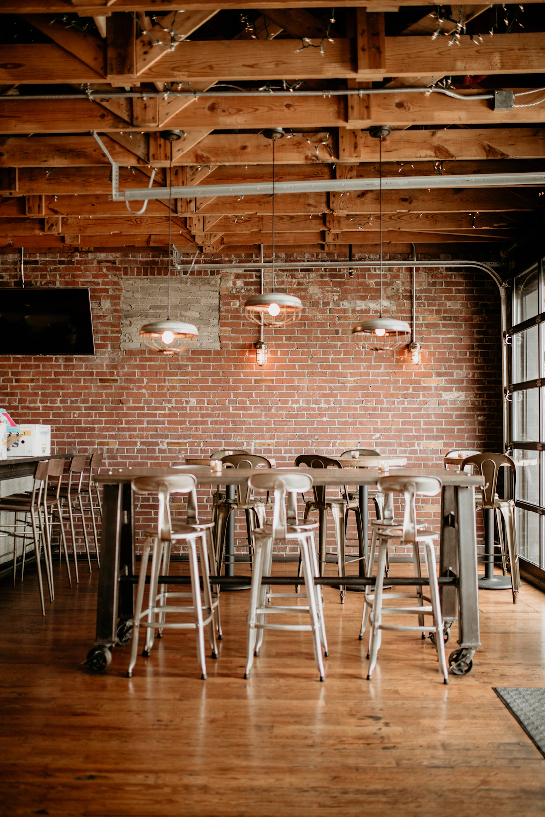 Salle de restaurant avec mur de briques et tabourets