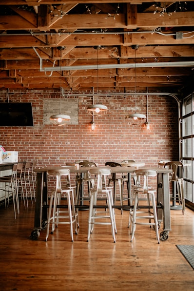 a brick wall with stools and a table in front of it