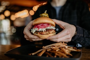 a person holding a burger