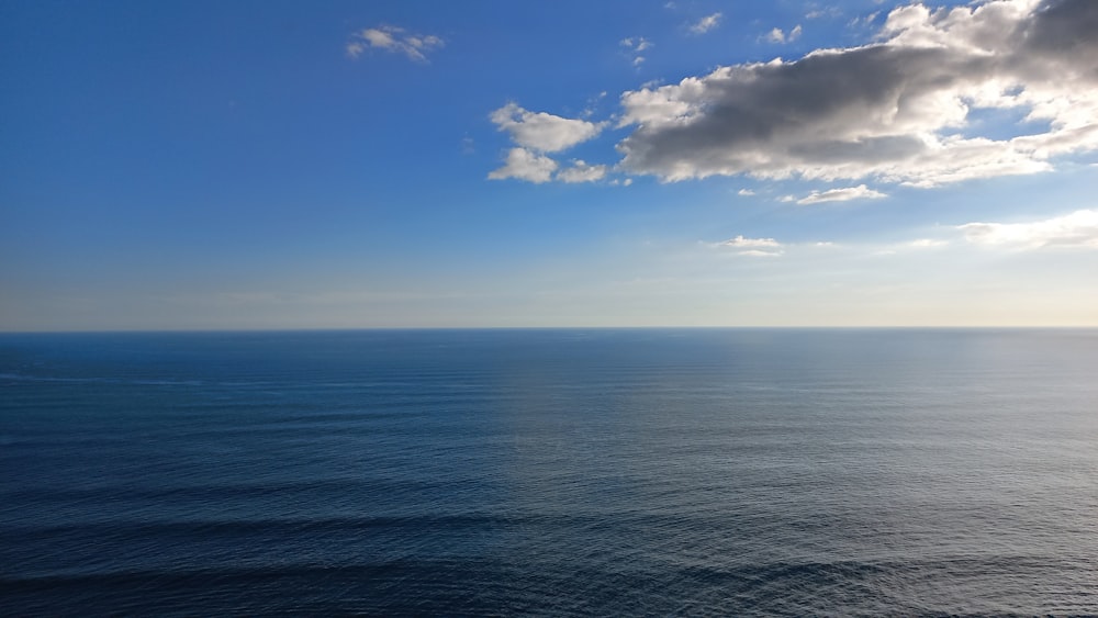 um corpo de água com nuvens acima dele