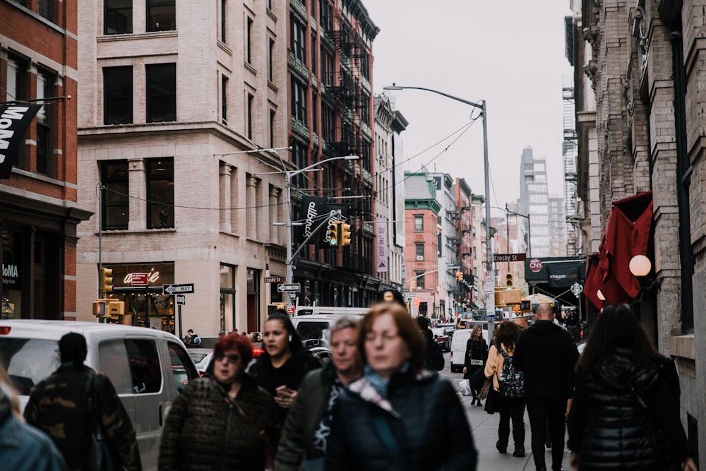 a crowd of people walking down a busy street