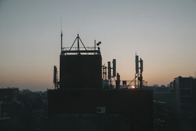 Crew members coordinating equipment on a vibrant city rooftop at dawn.