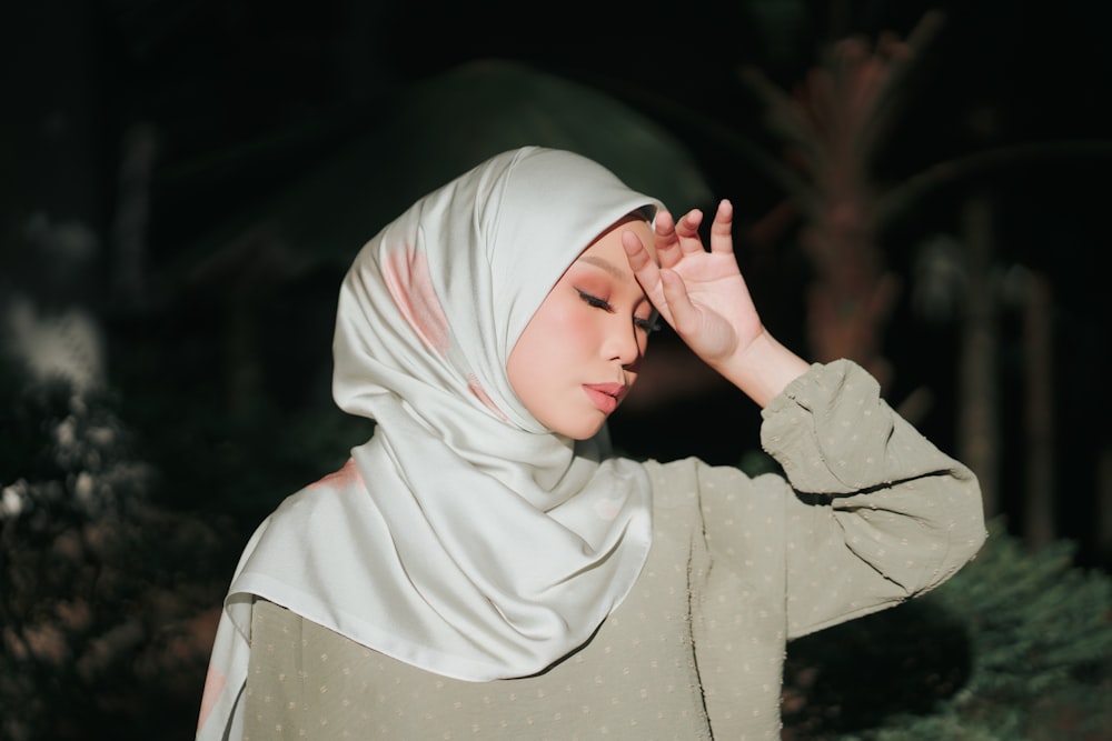 a person in a white hoodie holding a leaf