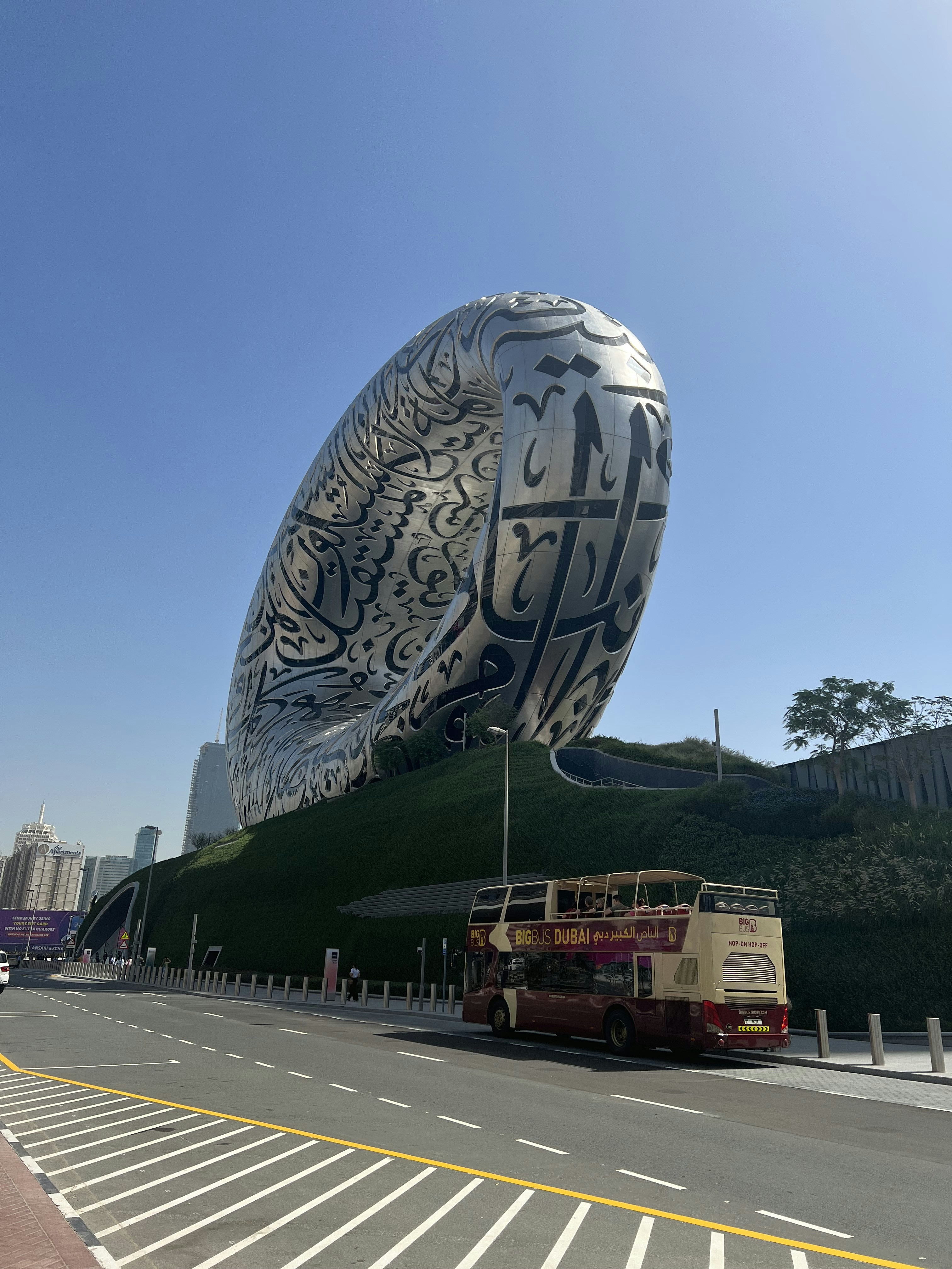 um ônibus estacionado em frente a uma grande escultura