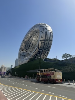 a bus parked in front of a large sculpture