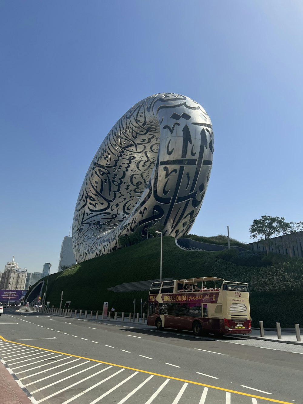 a bus parked in front of a large sculpture