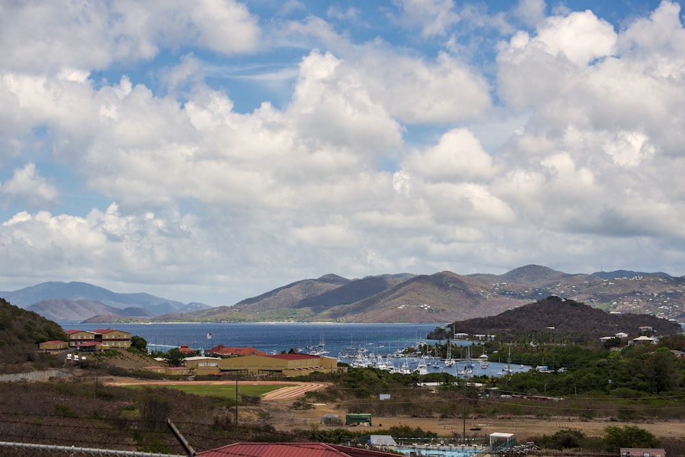 a landscape with buildings and trees by a body of water