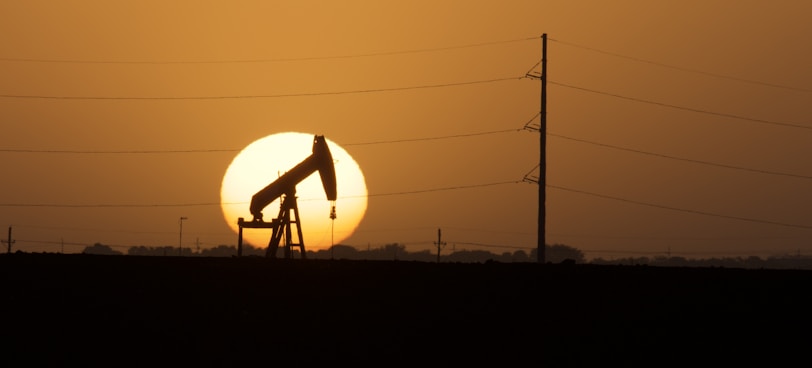 a silhouette of a person on a power line with a sunset in the background
