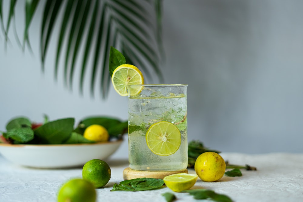 a glass of lemonade with limes and limes