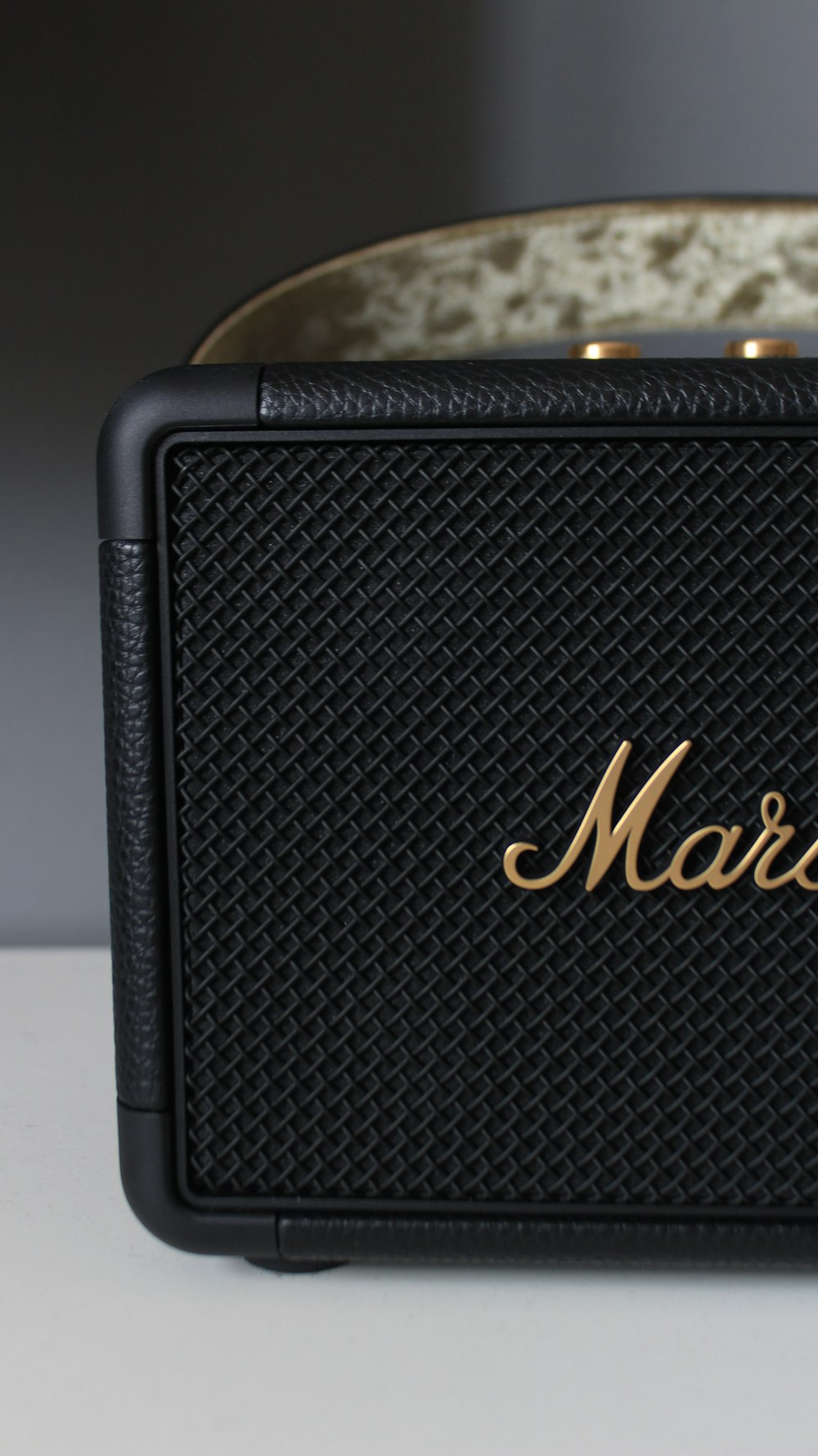 a black speaker with a gold logo