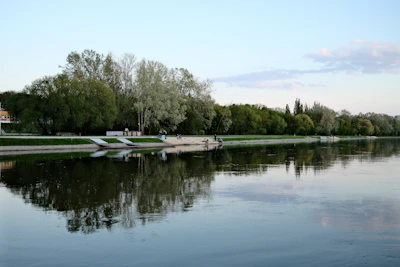 A serene riverside spot with travelers enjoying a peaceful day surrounded by lush greenery.