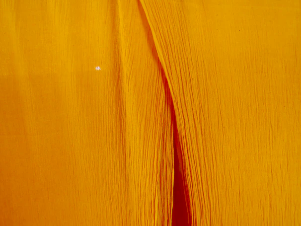 A close-up of a mustard yellow stretch fabric from the i stretch souls line, softly lit to show texture.