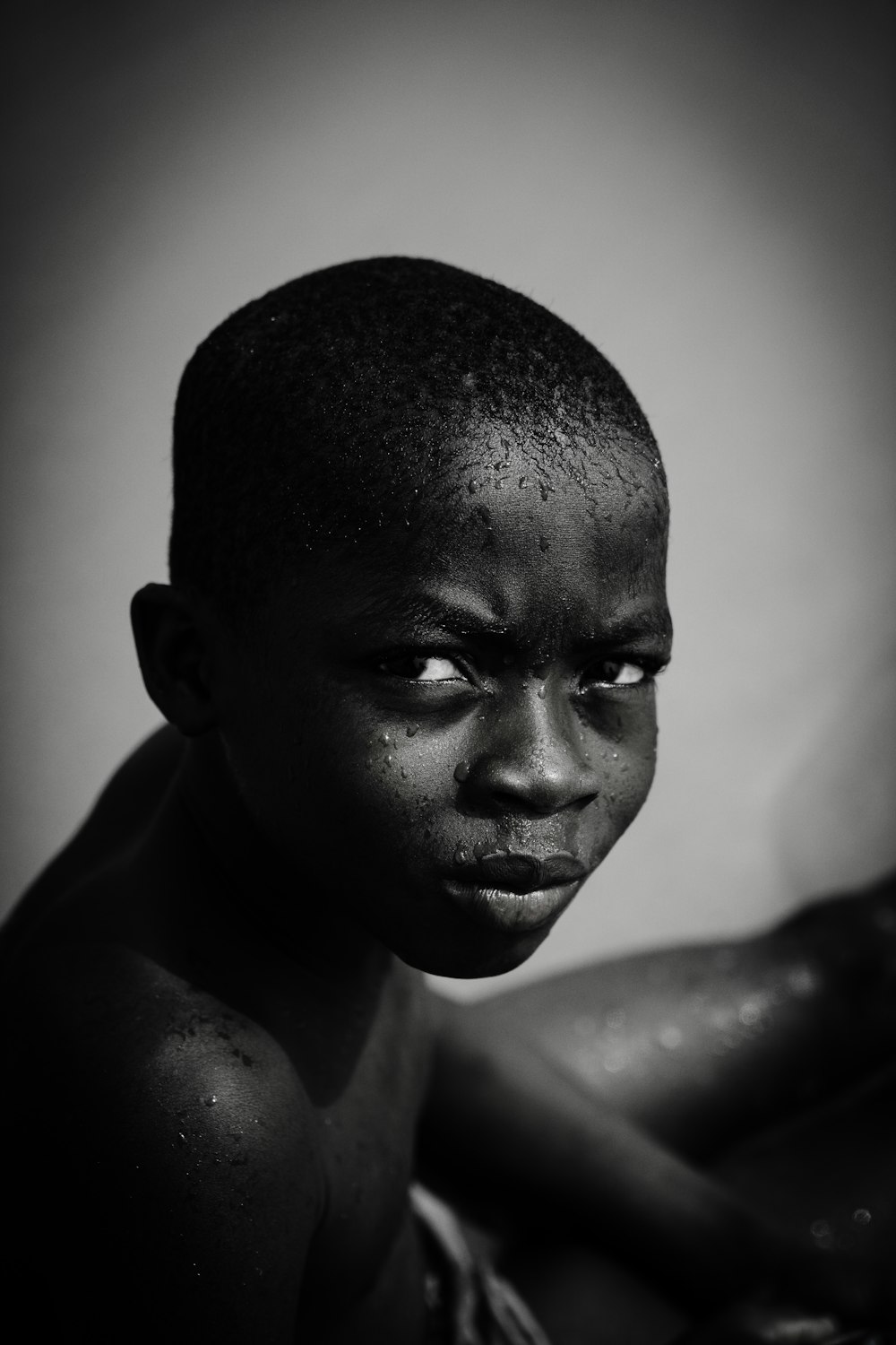 a black and white photo of a boy with no shirt